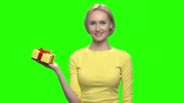 Ώριμη γυναίκα κρατώντας κίτρινη συσκευασία δώρου με το ένα χέρι. - Πλάνα, βίντεο