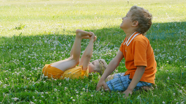 onnelliset pojat rentoutuvat puistossa
 - Materiaali, video