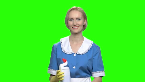 Toilet cleaner bottle adverticement. Woman in cleaner uniform pointing at toilet cleaner bottle. Green hromakey background for keying. - Footage, Video