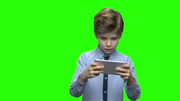 Маленький мальчик ребенок играет в игры на смартфоне
. - Кадры, видео