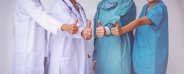 Médicos y enfermeras coordinan las manos.doctores pulgar hacia arriba, Concepto de Trabajo en Equipo
 - Foto, Imagen