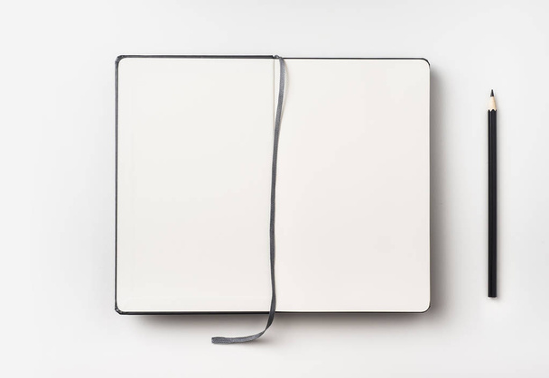 Business concept - Top view of black black notebook front with curve band and black pencil on background for mockup - Photo, Image