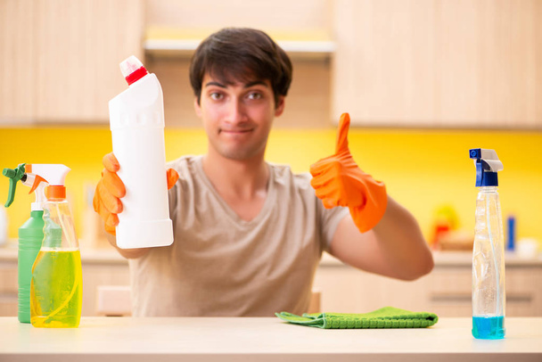 одинокий мужчина убирает кухню дома - Фото, изображение