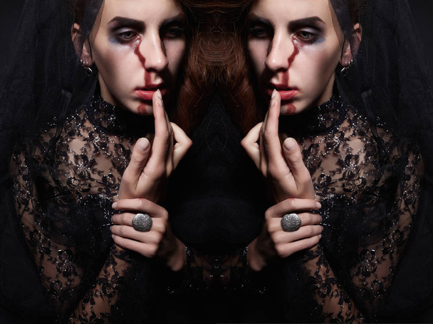 woman in black veil with a bloody face make-up.halloween costume.black widow - Photo, image