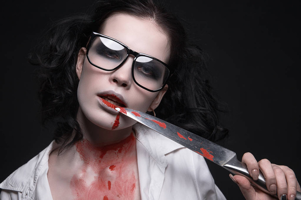 sexy student girl all in the blood with a knife.halloween make-up beautiful woman - Photo, image