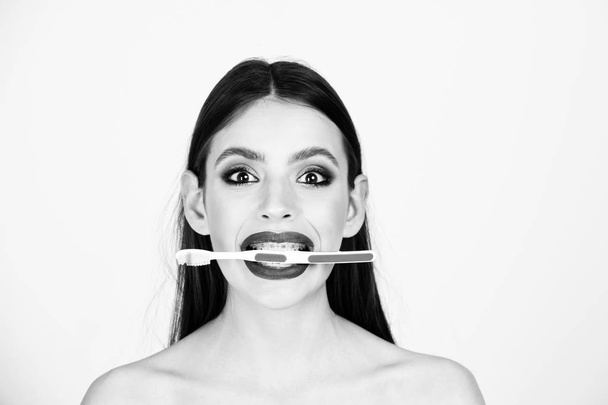 girl with teeth braces and brush, has fashionable makeup - Foto, afbeelding
