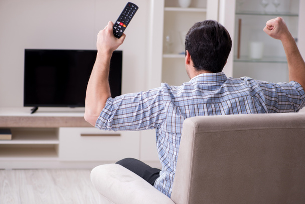 Jeune homme regardant la télévision à la maison - Photo, image