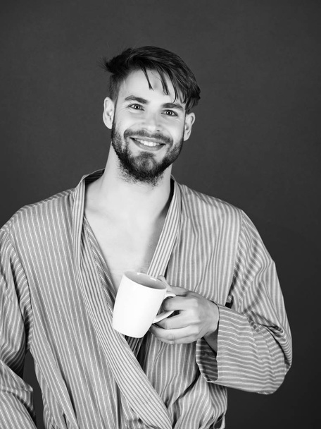 morning of man smiling in blue robe with cup in hand - 写真・画像