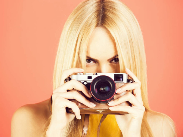 Pretty girl photographer photographing with retro camera - Фото, зображення