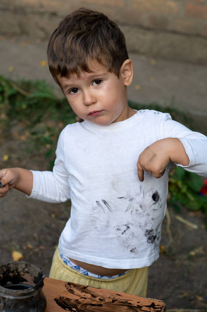 Malé dítě znázorňující bod na své špinavé prádlo. - Fotografie, Obrázek