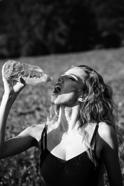 girl in field of poppy seed drink water from bottle - Zdjęcie, obraz
