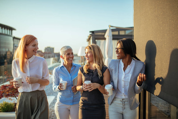Groupe de quatre femmes d'affaires parlant
 - Photo, image