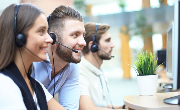 Attractive positive young businesspeople and colleagues in a call center office. - Foto, Imagem