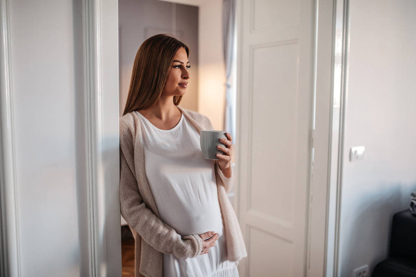Portrait of pregnant woman drinking coffee. - Photo, image