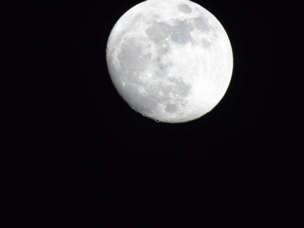  Una fotografía increíble de la luna llena bajo un cielo oscuro con algunas pequeñas estrellas en el fondo
 - Foto, imagen