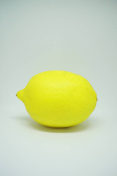 Limón amarillo sobre una mesa gris
 - Foto, imagen