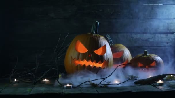 Halloween pumpkins head jack o lantern and candles in blue light and mist - Footage, Video