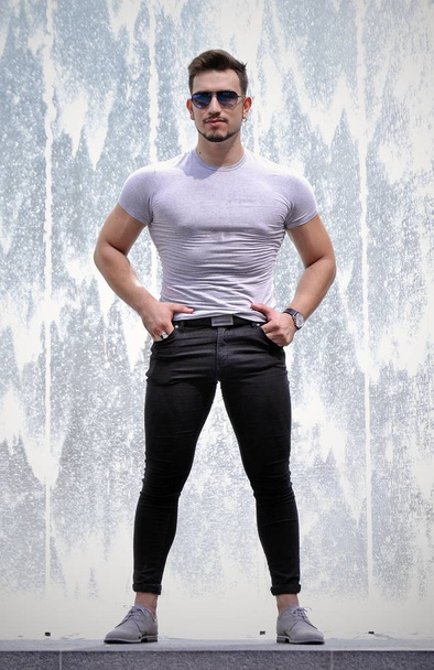 Young fitnest man portrait on bstract water background - 写真・画像