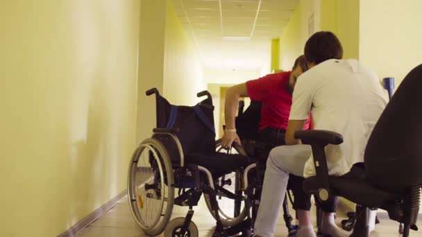 Mladá zakázat muž mění lavice na invalidní vozík - Záběry, video
