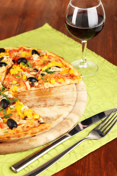 Tasty pizza with wine on wooden table close-up - 写真・画像