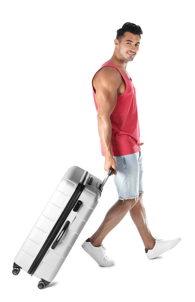 Young man walking with suitcase on white background - Foto, immagini