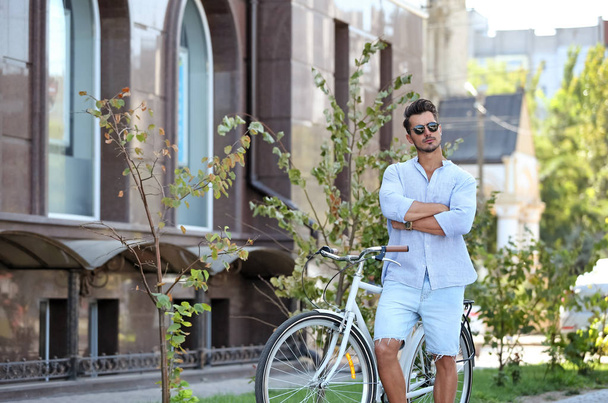 Handsome young hipster man with bicycle outdoors - Fotografie, Obrázek