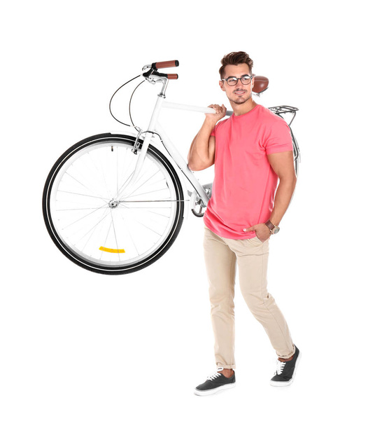 Handsome young hipster man with bicycle on white background - Fotó, kép