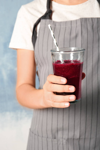 Woman with glass of beet smoothie on color background, closeup - Foto, imagen