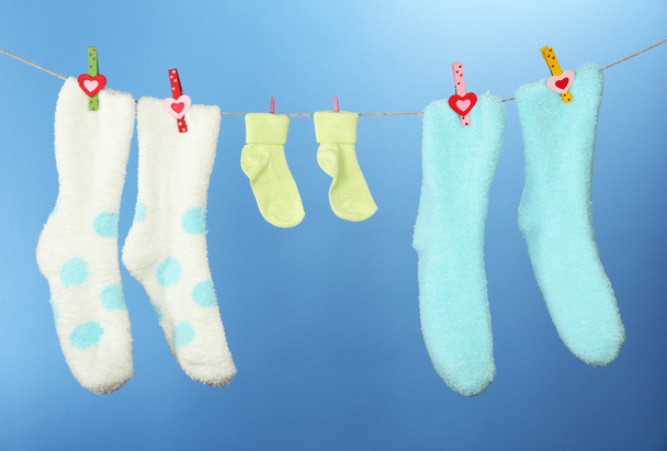 Värikkäät sukat roikkuvat pyykkinarulla, väritaustalla
 - Valokuva, kuva