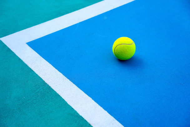 Tennis ball on hard modern blue court near white line - Fotoğraf, Görsel