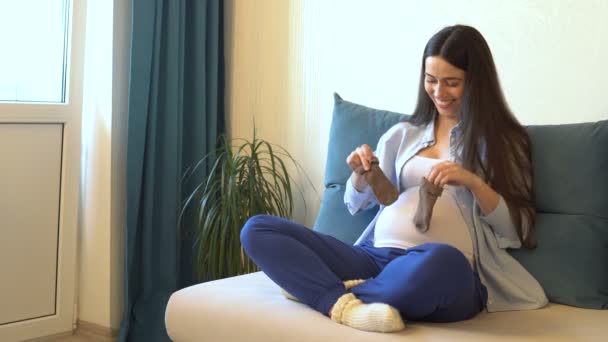 pregnant woman holding blue socks - Кадры, видео