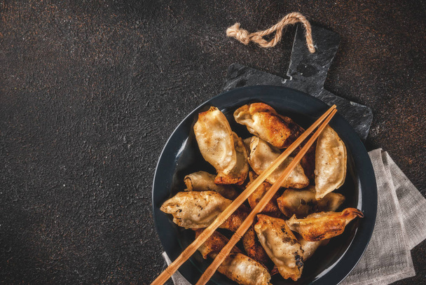 Kızarmış Asya köfte sosu karanlık tabakta servis chopsticks ve soya sosu, koyu arka plan, kopya alanı ile - Fotoğraf, Görsel