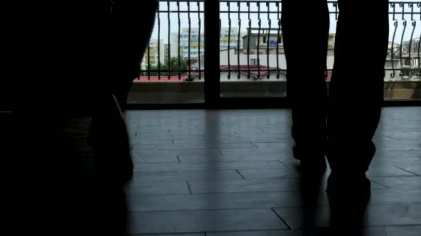 Füße von Geschäftsmann und Geschäftsfrau gehen in Silhouette in Richtung der Bürofenster - Filmmaterial, Video