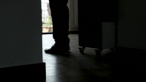 Feet in silhouette of businessman and businesswoman walking through the office - Footage, Video