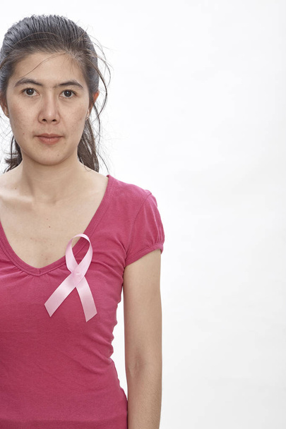 Kadın pembe kanser şerit göğüs üzerinde. Sağlık, tıp ve meme kanseri bilinçlendirme kavramı. Stüdyo vurdu, açık beyaz renkli, sigorta sağlık sistemi - Fotoğraf, Görsel