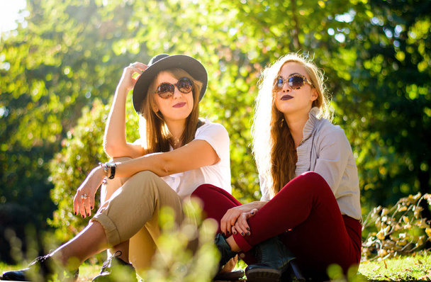 Two girl friends enjoying an autumn day in the park - Photo, image