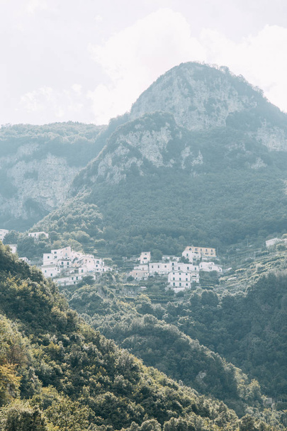 The Amalfi coast and the mountain slopes with plantations of lemons. Panoramic view of the city and nature of Italy. Evening landscapes and winding roads. Sky over the sea and rocks. - Photo, Image