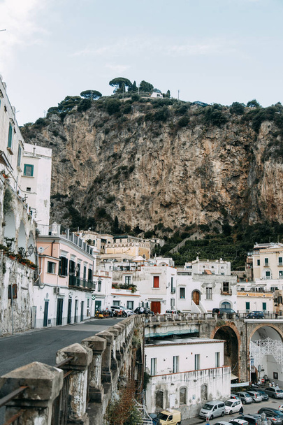 The Amalfi coast and the mountain slopes with plantations of lemons. Panoramic view of the city and nature of Italy. Evening landscapes and winding roads. Sky over the sea and rocks. - Фото, изображение