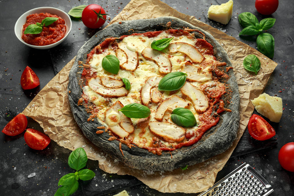 Kő sült fekete Pizza, csirke, paradicsom és mozzarella sajt - Fotó, kép