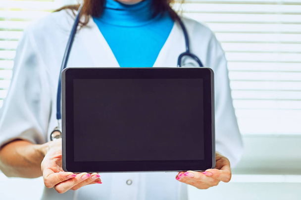 Woman doctor using tablet computer in hospital - Foto, afbeelding