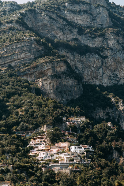 The coast of Positano, Amalfi in Italy. Panorama of the evening city and the streets with shops and cafes. Houses by the sea and the beach. Ancient architecture and temples. View from a postcard on top - Foto, Bild