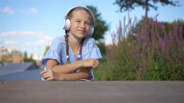 Piccola adorabile ragazza che ascolta musica nel parco
 - Filmati, video