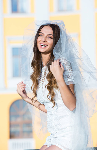 Fashion photo of a beautiful bride. Happy bride in a stylish white dress. Stylish wedding bride with bouquet and amazing modern dress. - Photo, Image