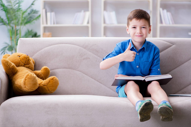 Kleine jongen die thuis boeken leest - Foto, afbeelding