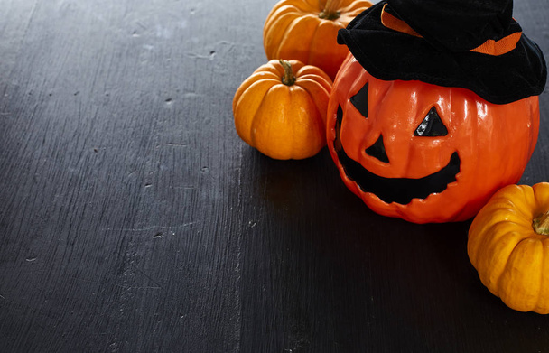 Halloween pompoenen Jack O Lantern op zwart houten achtergrond met kopie ruimte - Foto, afbeelding