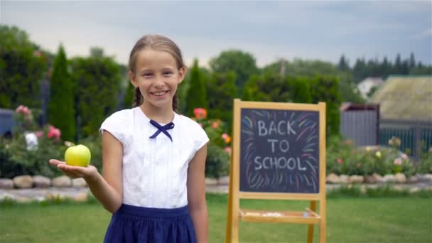 Ευτυχισμένος μικρή μαθήτρια με ένα μαυροπίνακα εξωτερική - Πλάνα, βίντεο