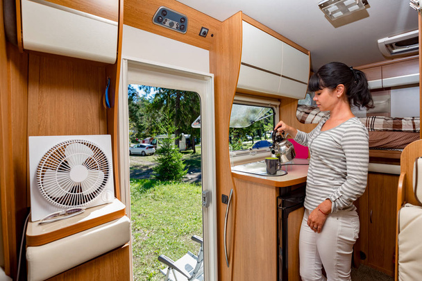 Woman cooking in camper, motorhome interior VR. Family vacation travel, holiday trip in motorhome, Caravan car Vacation. - Photo, Image
