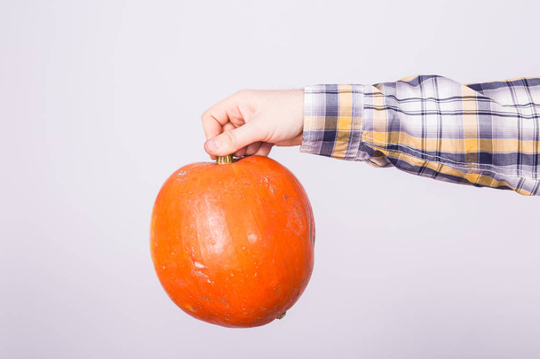 Autumn, harvest and holidays concept - Pumpkin in male hand on white background. - Photo, Image