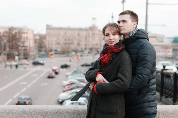 young man and woman hugging in winter city, romantic happy couple  - Fotó, kép