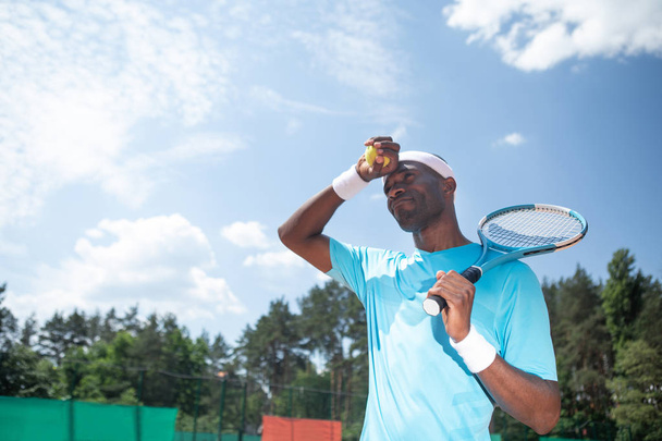 Tennis player is preparing to serve under sun - 写真・画像